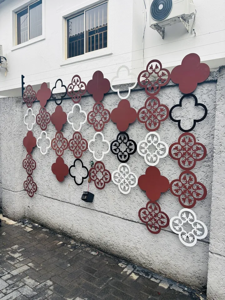 Burgundy, white and black decorative metal panels on an exterior wall